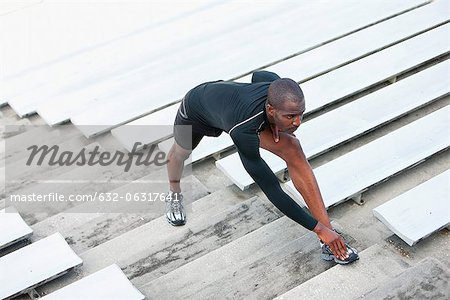 Man stretching on bleacher steps