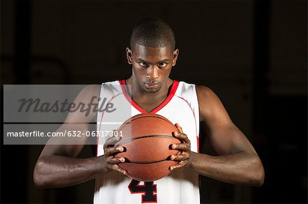 Basketball player holding basketball, portrait