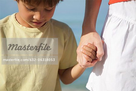 Boy holding mother's hand, cropped