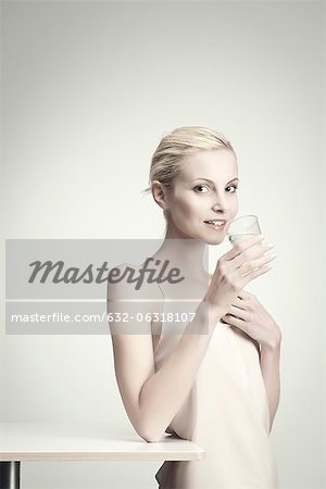 Young woman holding glass of water, portrait