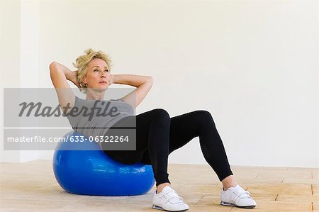 Mature woman doing sit-ups on fitness ball