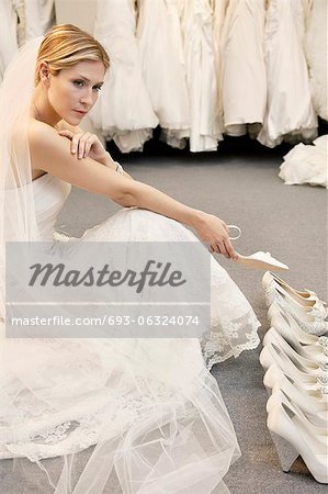 Beautiful young woman confused with footwear selection in bridal store