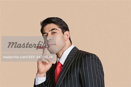 Porträt eines jungen Kaufmanns mit Roter Chili zu imitieren, als Rauchen Zigarette