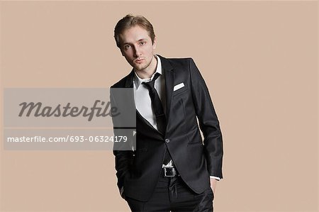 Porträt des jungen Geschäftsmann mit Händen in den Taschen über farbigen Hintergrund