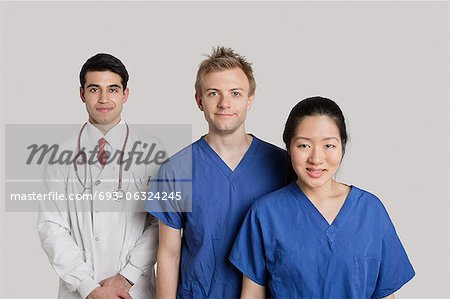 Portrait of happy medical team standing over gray background