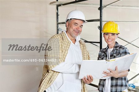 Portrait of happy team of architect with paper documents at construction site