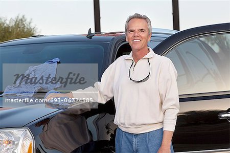 Portrait d'homme mûr, debout à côté de sa voiture