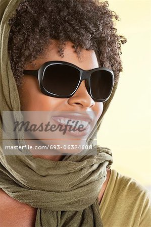 Happy African American wearing sunglasses with stole over her head