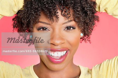 Close-up Portrait ein Afroamerikaner Frau lächelnd über farbigen Hintergrund