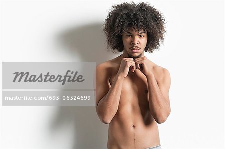 Portrait of young man with fist standing over white background