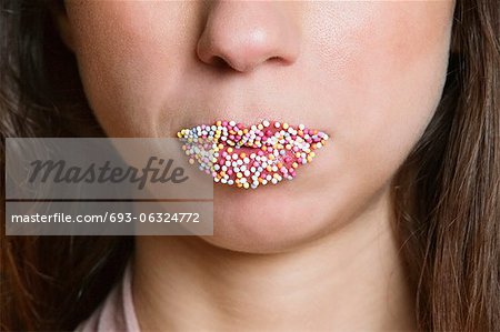 Image rognée de femme lèvres saupoudré de bonbons