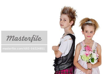 Portrait de garçon punk avec demoiselle d'honneur, tenant un bouquet de fleurs sur fond blanc