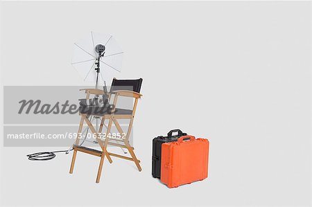 Director's chair and reflector umbrella with suitcase in studio