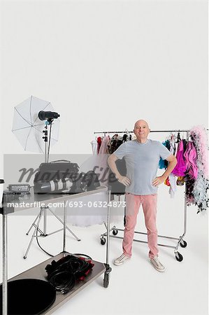 Portrait d'un homme senior avec les mains sur les hanches, debout devant l'étendoir en studio