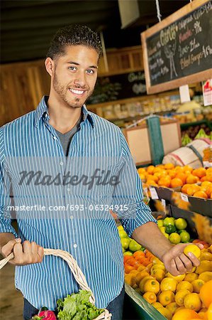 Portrait of handsome young man shopping for fruits in market