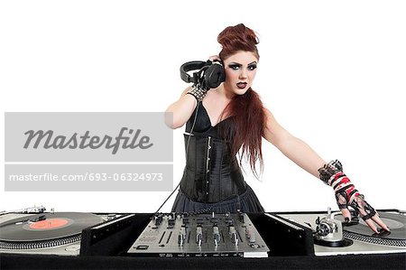 Portrait of beautiful young DJ listening to music over white background
