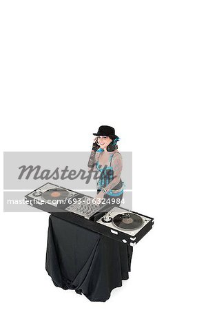 Portrait de jeune DJ avec mixage matériel portant chapeau sur fond blanc