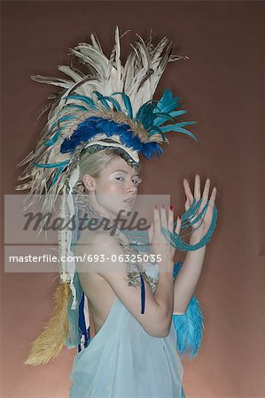 Portrait de jeune femme en tenue à plumes sur fond coloré