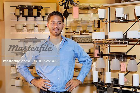 Portrait d'un bel homme debout les mains sur les hanches dans le magasin de lumières