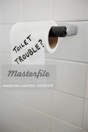 Close-up of text written on tissue paper in bathroom depicting toilet problems