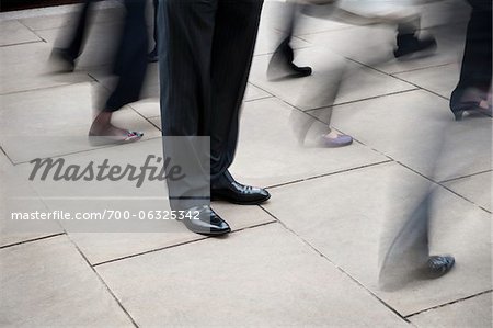 Businessman Standing Still Amongst Pedestrian Traffic