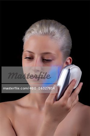 Young woman getting photo-therapy treatment with blue light