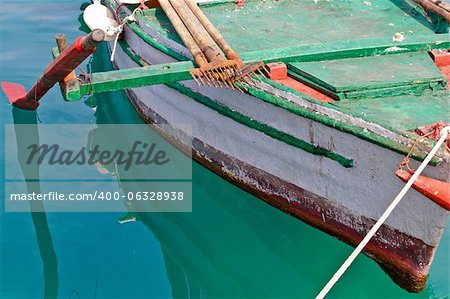 Old wooden colorful fishing boat detail with rusty fish gig