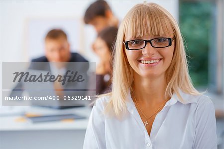 Smiling business woman with her working friends at the background