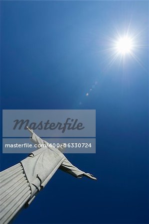 Corcovado Christ the Redeemer stands in blue sky under bright sun in Rio de Janeiro Brazil