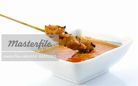 Delicious Satay chicken and peanut sauce over white background