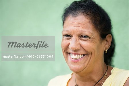 Portrait of happy elderly hispanic lady smiling at camera. Copy space