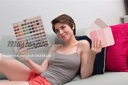 Jeune femme sur le canapé, regardant les nuanciers de couleurs