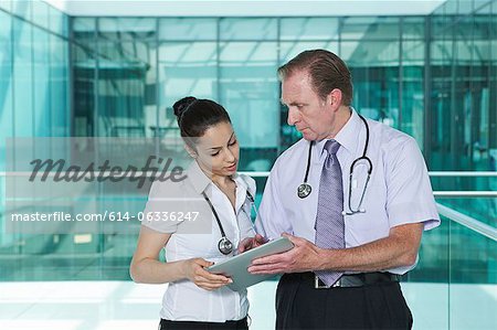 Doctors discussing medical records on digital tablet