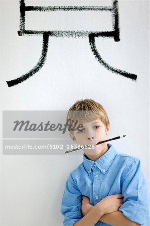 Boy holding paintbrush in mouth