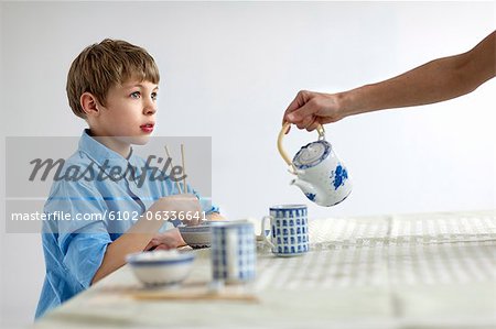 Garçon de manger avec des baguettes