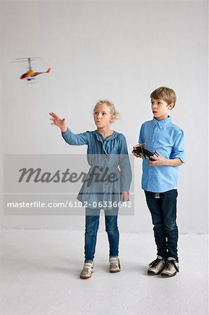 Boy and girl playing with helicopter model