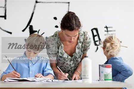 Boy, girl and female teacher caligraphing chinese signs