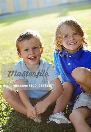 Portrait des deux garçons assis sur l'herbe