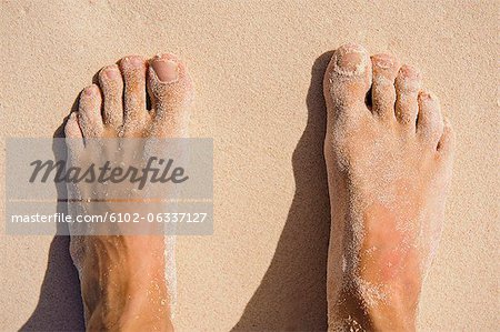 View of mans feet on sand