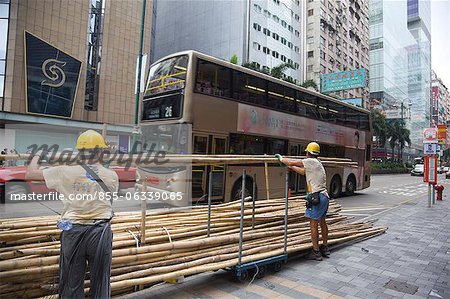 Workers arranging bamboos for scaffolding on Nathan Road, Kowloon, Hong Kong