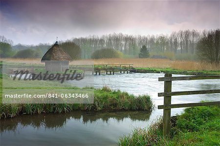Thatched fisherman's hut and eel traps spanning the River Test near Leckford, Hampshire, England, United Kingdom, Europe