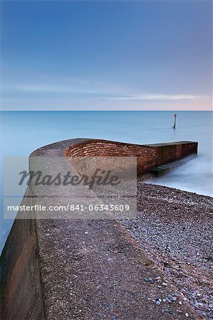 Stone jetty on Sidmouth beachfront at sunset, Sidmouth, Devon, England, United Kingdom, Europe