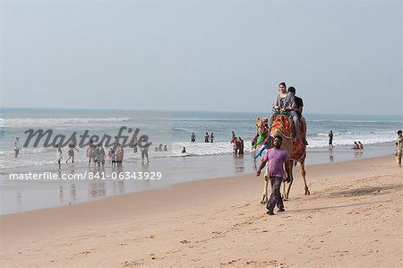 Indiens vacanciers sur la plage de Puri, prise de famille jeune chameau balade le long de la plage, Puri, golfe du Bengale, Orissa, Inde, Asie