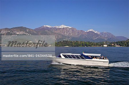 Pleasure boat crossing Lake Como from Bellagio in spring sunshine, Lombardy, Italian Lakes, Italy, Europe