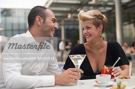 Souriant couple ayant des boissons en plein air