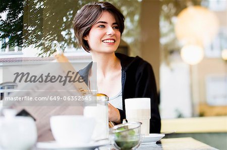 Woman reading newspaper in cafe