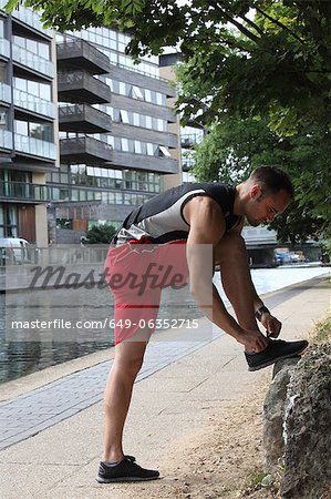 Runner tying his shoes on city street