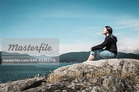 Woman relaxing by rural lake