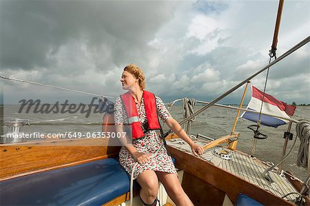 Woman steering boat on rocky water
