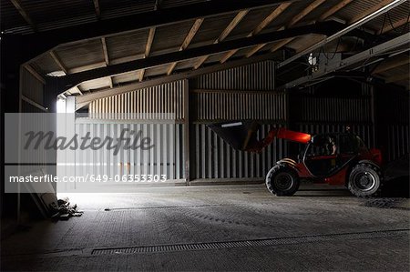 Landwirt treibende Bagger in Schuppen